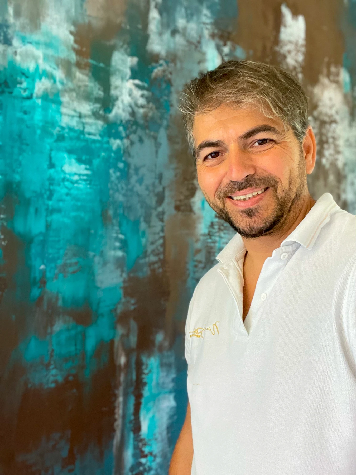 Ritratto di Nicola Spulber davanti a una parete turchese e bronzo