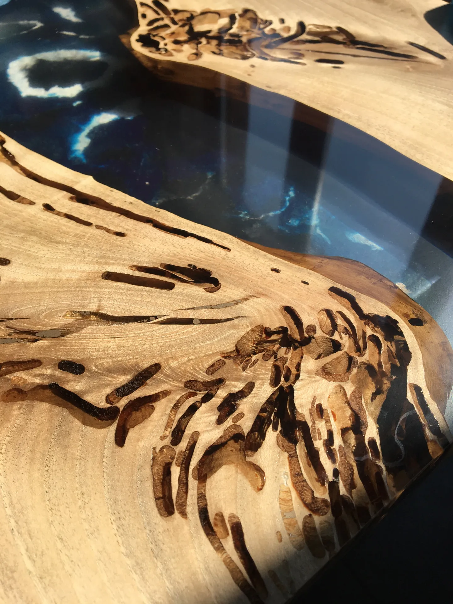 Dettaglio delle gallerie naturali nel legno accanto alla resina