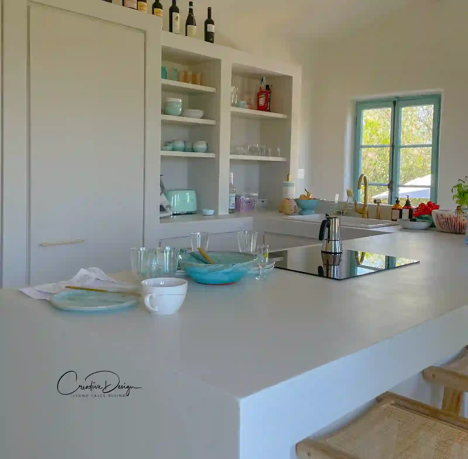 Cucina bianca con piano continuo e finestra